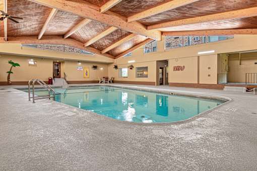 A large indoor swimming pool with a wooden ceiling.