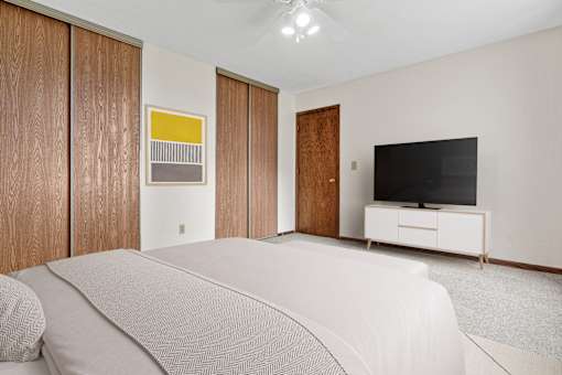 A bedroom with a bed, a television, and a cabinet.