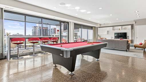 a pool table in a living room with a view of the city