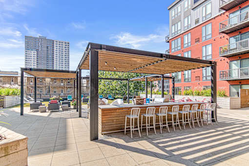 a rendering of a rooftop bar and patio with a city skyline in the background