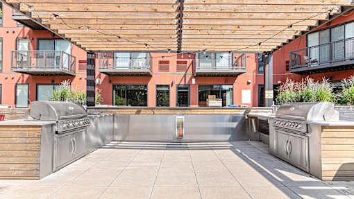 an outdoor kitchen with stainless steel appliances and a wooden canopy