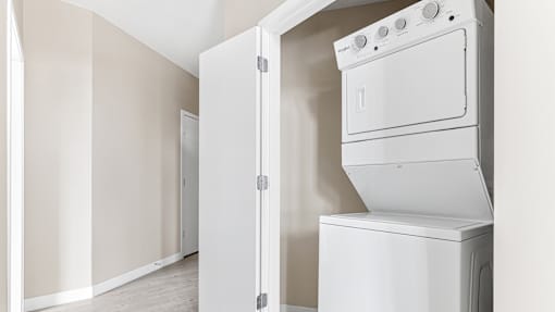 an empty laundry room with a washer and dryer in it