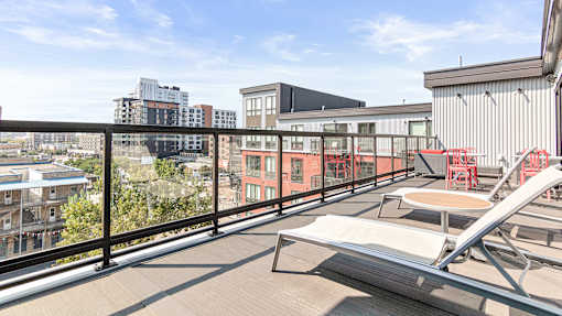 a balcony with a view of the city and a chair and a table