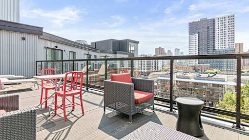 a balcony with a view of the city and chairs and tables