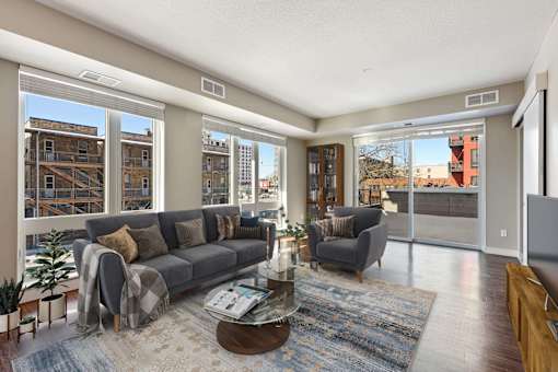 Open living spaces with large windows and glass doors leading out to the private balcony or patio.
