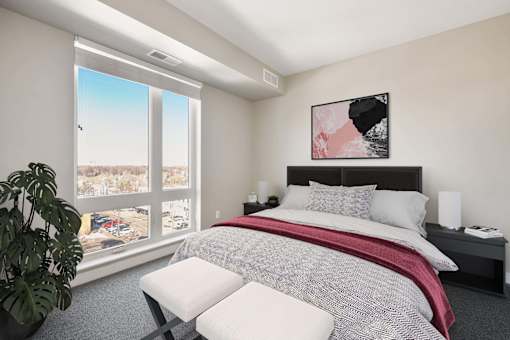 Spacious bedroom with a large window reaching the floor.