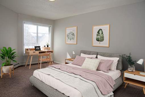 Spacious bedroom with a large window letting in natural light.