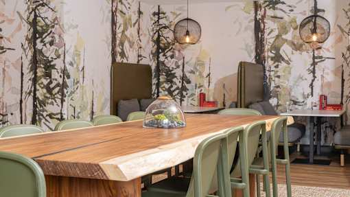 a dining room with a wooden table and green chairs