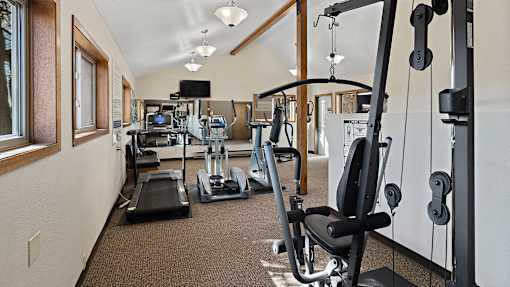 a gym with cardio machines and weights on the floor
