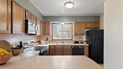 a kitchen with black appliances and wooden cabinets
