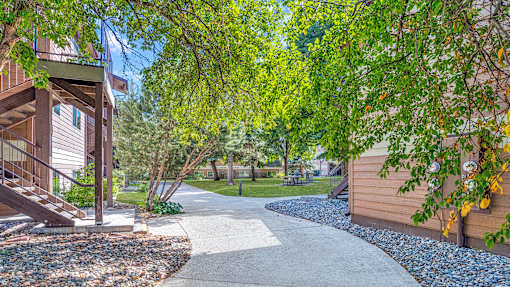 a walkway leading to a house with trees and a sidewalk