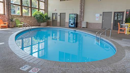a swimming pool with blue water and brick flooring