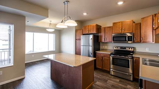 an empty kitchen with wooden cabinets and stainless steel appliances