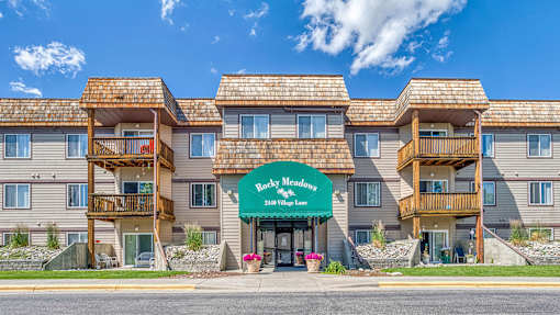 a large apartment building with a green sign in front of it