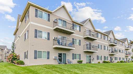 the view of an apartment building with balconies and a lawn