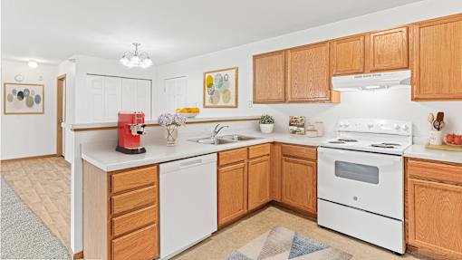 a kitchen with white appliances and wooden cabinets