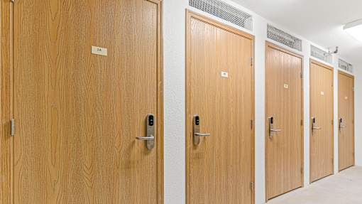 a row of four wooden doors in a hallway