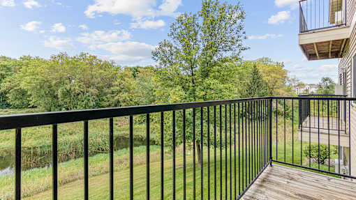 a balcony with a view of a yard and trees