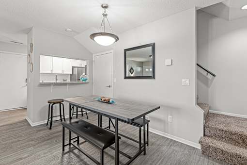 A dining room with a table and chairs.