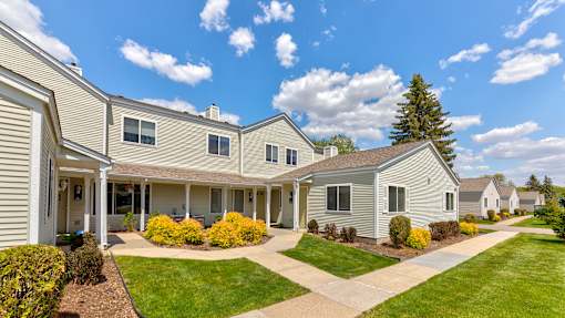 a group of houses with lawns and trees in front of them