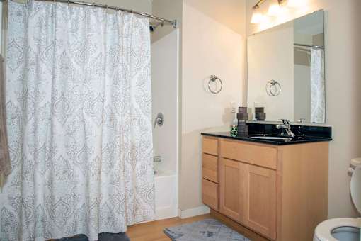 Private master bathroom with full shower and large mirror above sink.
