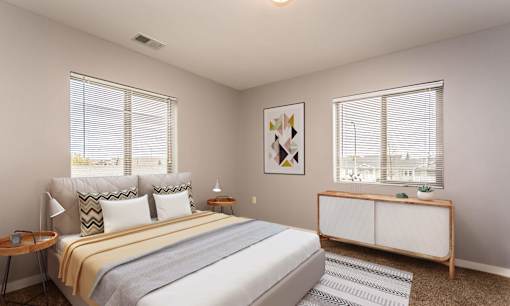 Spacious bedroom with two large windows brightening the space.