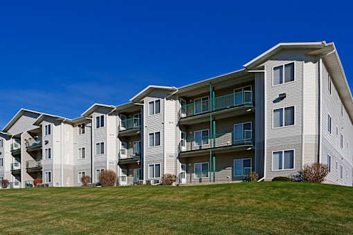 A large apartment complex with multiple balconies and green railings.