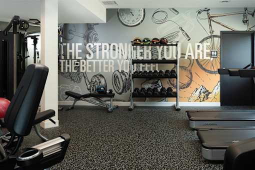 A gym room with a wall mural that says "The stronger you are, the better you feel.".