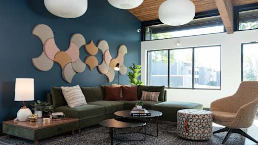 a living room with blue walls and a green couch at The Bosk Apartment Homes, Woodbury, MN, 55125