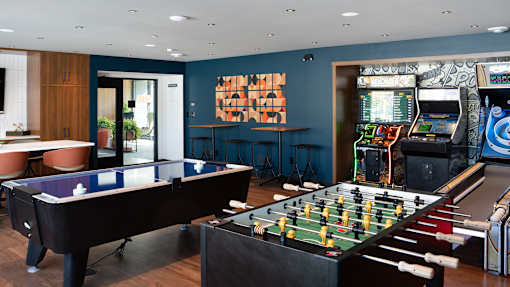 a game room with a foosball table and a video game at The Bosk Apartment Homes, Minnesota 55125