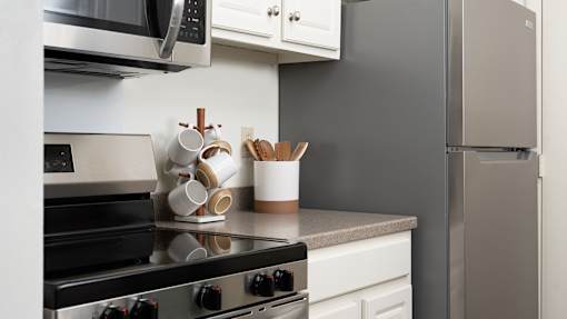 a kitchen with a stove and a refrigerator at The Bosk Apartment Homes, Woodbury, 55125