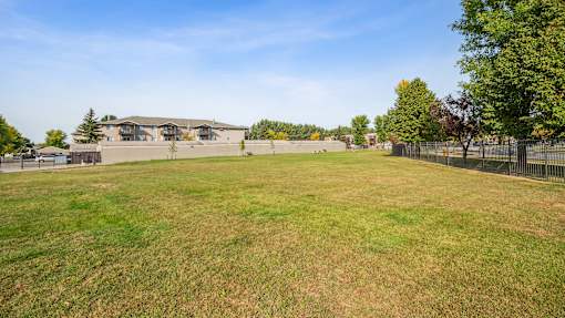 A large grassy field with a building in the background.