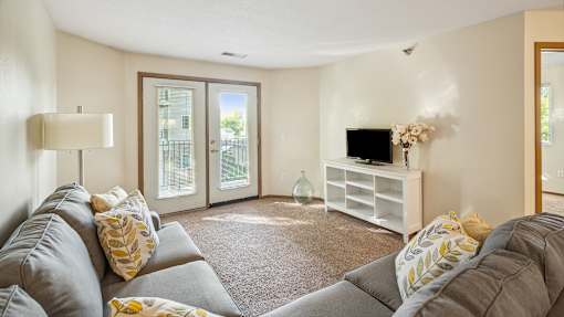 A living room with a grey couch and a white entertainment center.