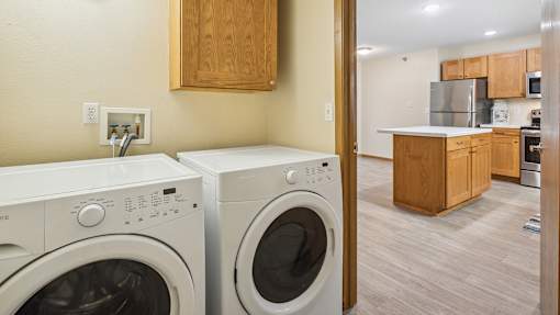 Two front load washing machines in a laundry room.