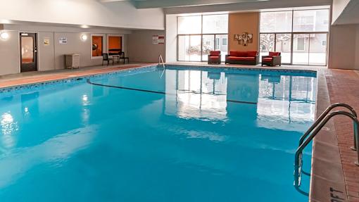 a large indoor pool with chairs and a couch next to it