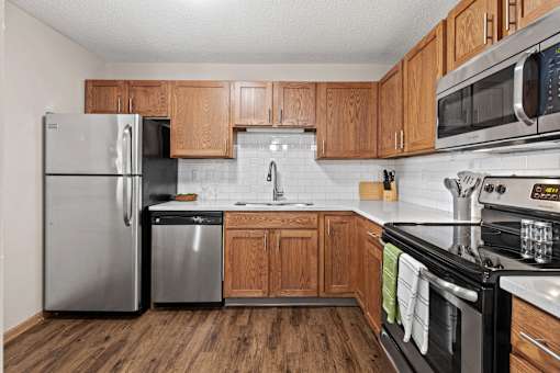 A kitchen with wooden cabinets and a black stove top oven.
