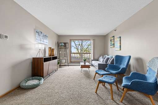 A living room with a blue chair and a grey couch.