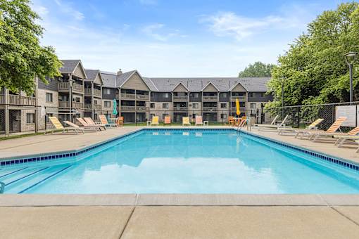A large swimming pool in front of apartment buildings.