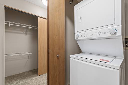 A white dryer is in a small laundry room.