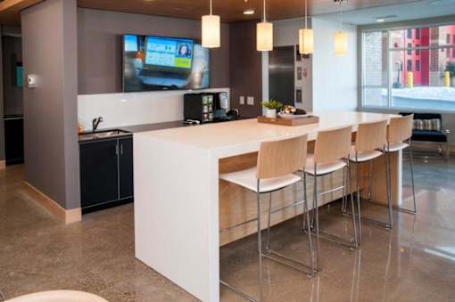Zest Community kitchen with island, seating and tv