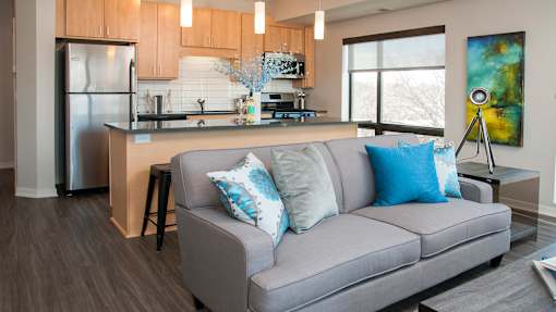 a living room with a couch in front of a kitchen
