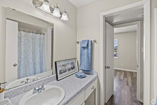 A bathroom with a white sink and a mirror above it. at La Bella Apartments, Fort Worth, 76116