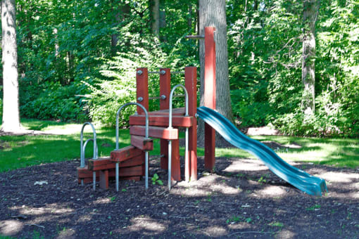 a playground with a wooden bench and a blue slide