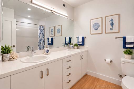 A bathroom with a white toilet, sink, and mirror.