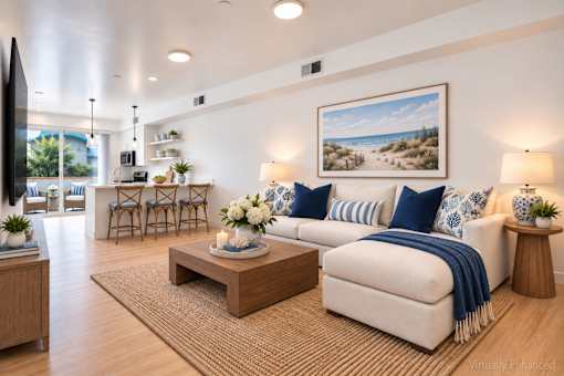 A living room with a white couch, a coffee table, and a painting on the wall.