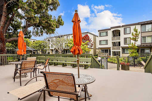 an outdoor patio with tables and chairs and umbrellas