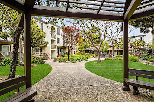 a view of a courtyard with benches and buildings