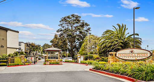 a villa with a driveway and a sign that says Peninsula Pines Apartments