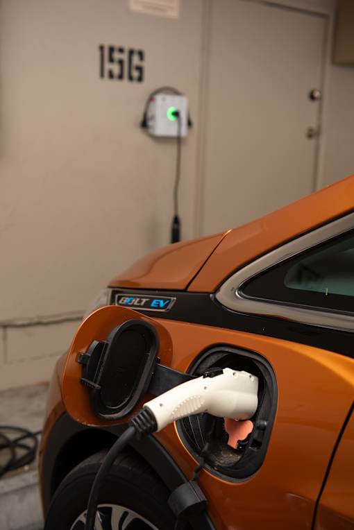 An orange car is charging at a 15G charging station.