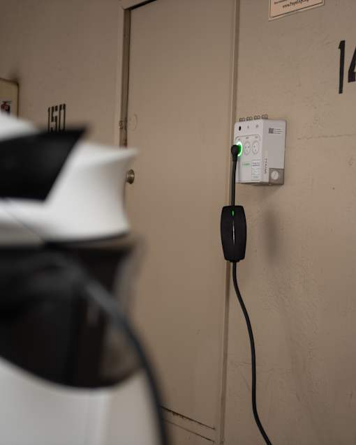 A black plug is connected to a white outlet.